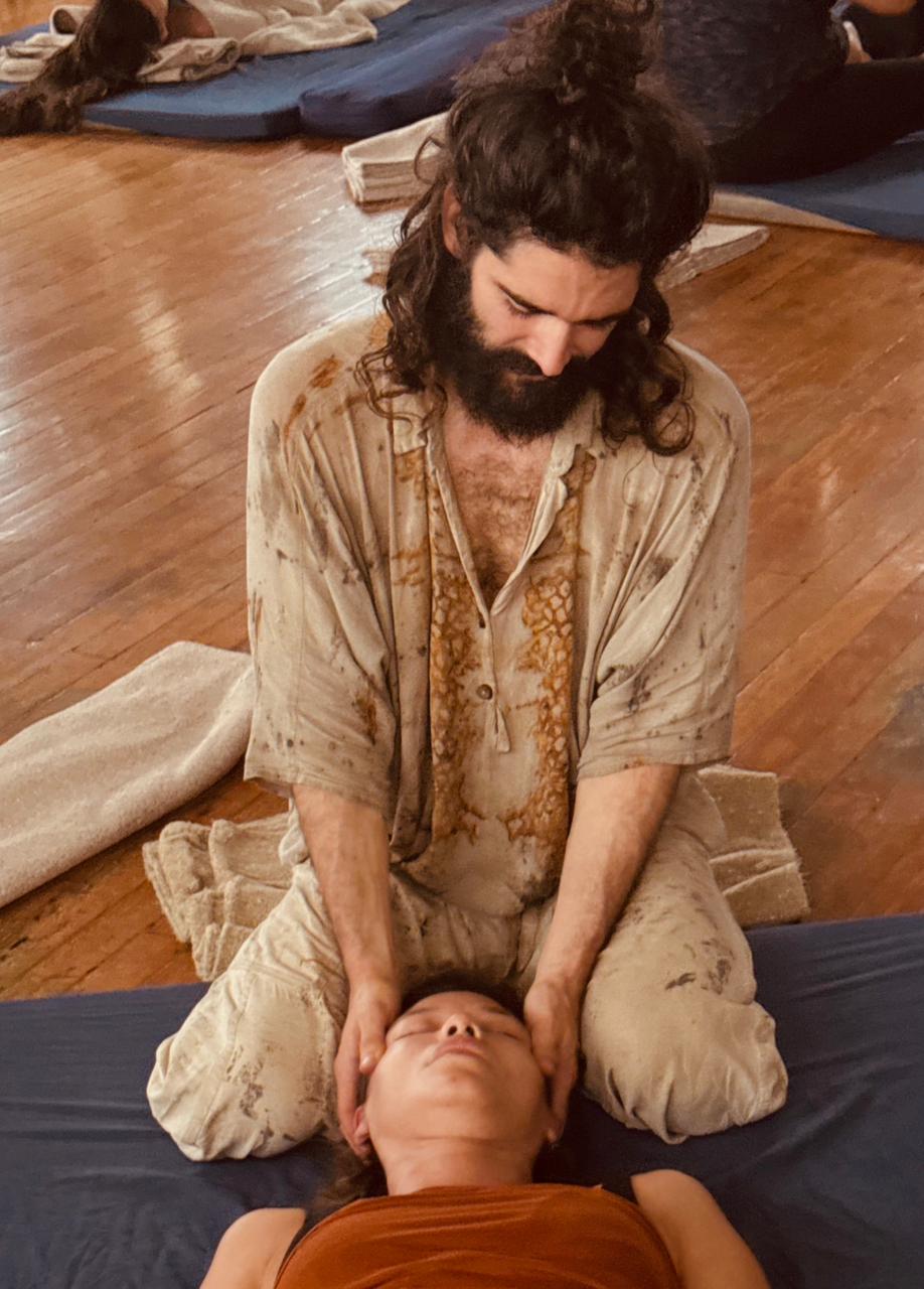 Atabey holding a client's head in stillness