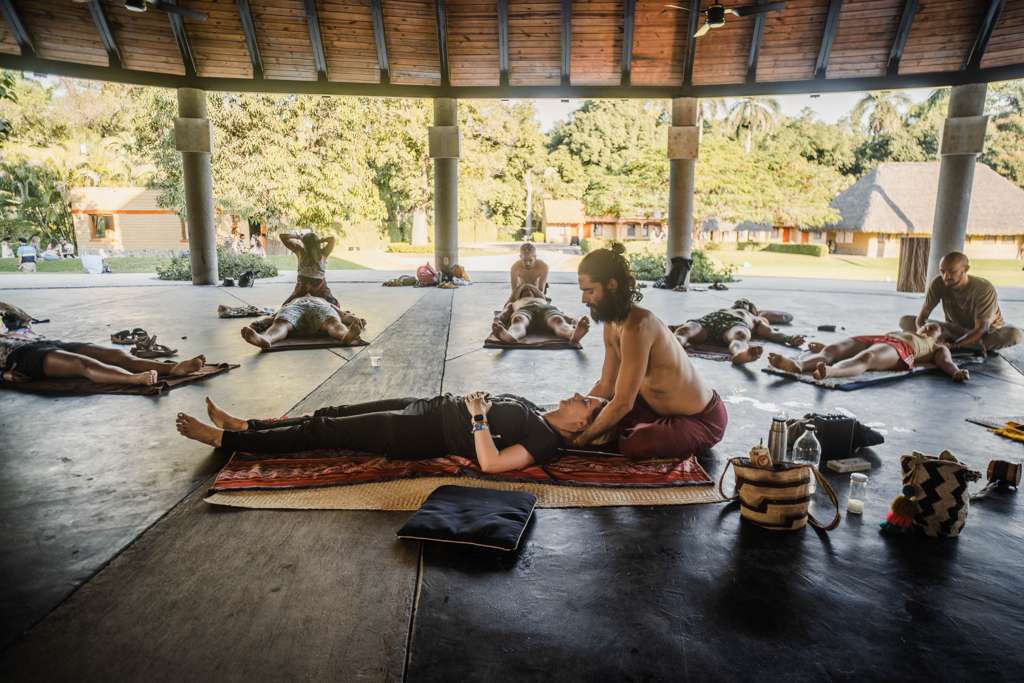 Atabey leading a group bodywork session in an open-air pavilion